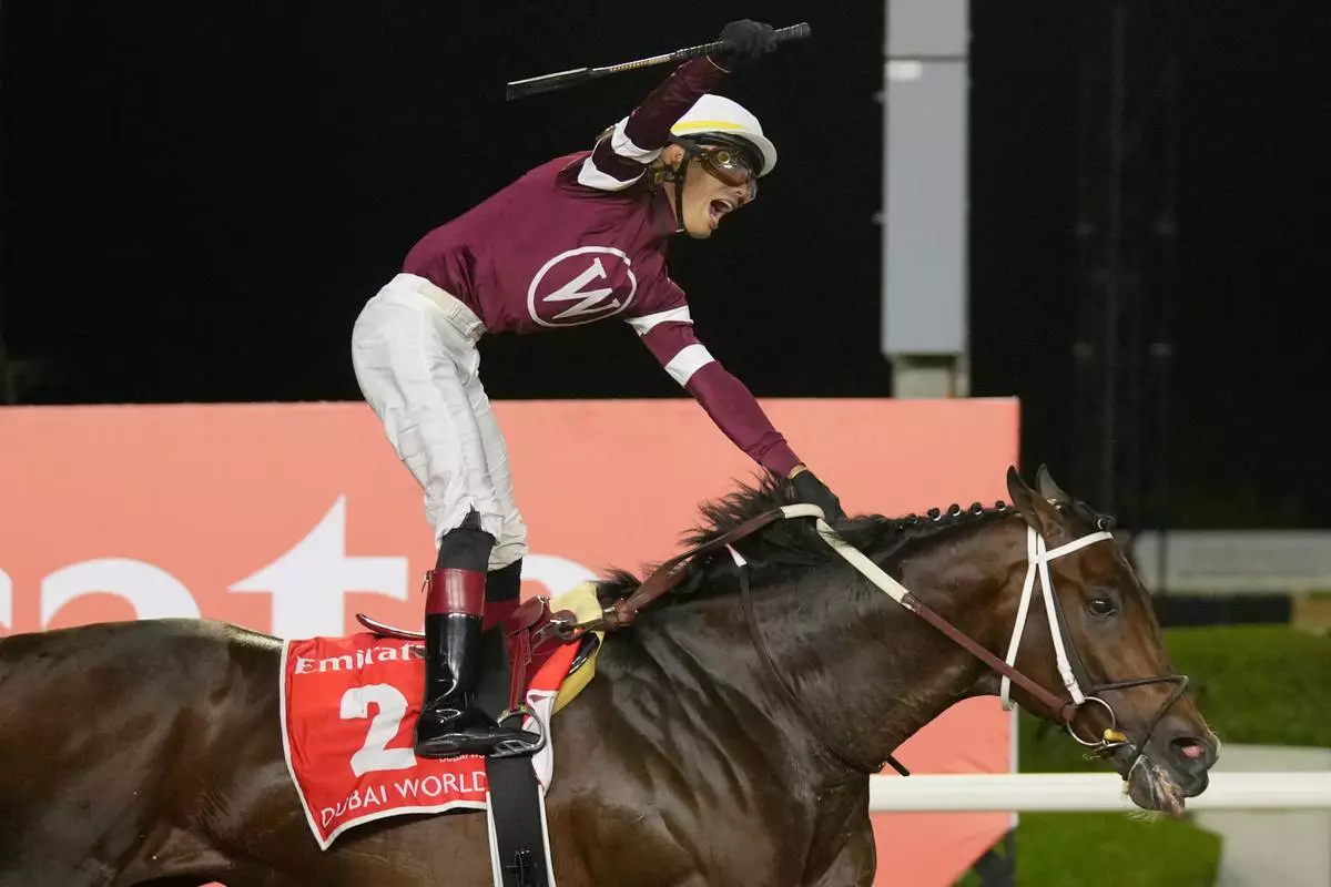 Jockey Jose Ortiz, aboard Magnitude, celebrates winning the $12 million Dubai World Cup horse race over 2000m (10 furlongs) at Meydan Racecourse in Dubai, the United Arab Emirates, Saturday, March 28, 2026. (AP Photo/Altaf Qadri)