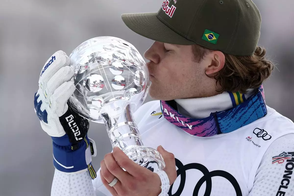 Brazil's Lucas Pinheiro Braathen kisses the globe trophy for the alpine ski, men's giant slalom discipline title, at the Lillehammer World Cup Finals, in Hafjell, Norway, Tuesday, March 24, 2026. (AP Photo/Gabriele Facciotti)