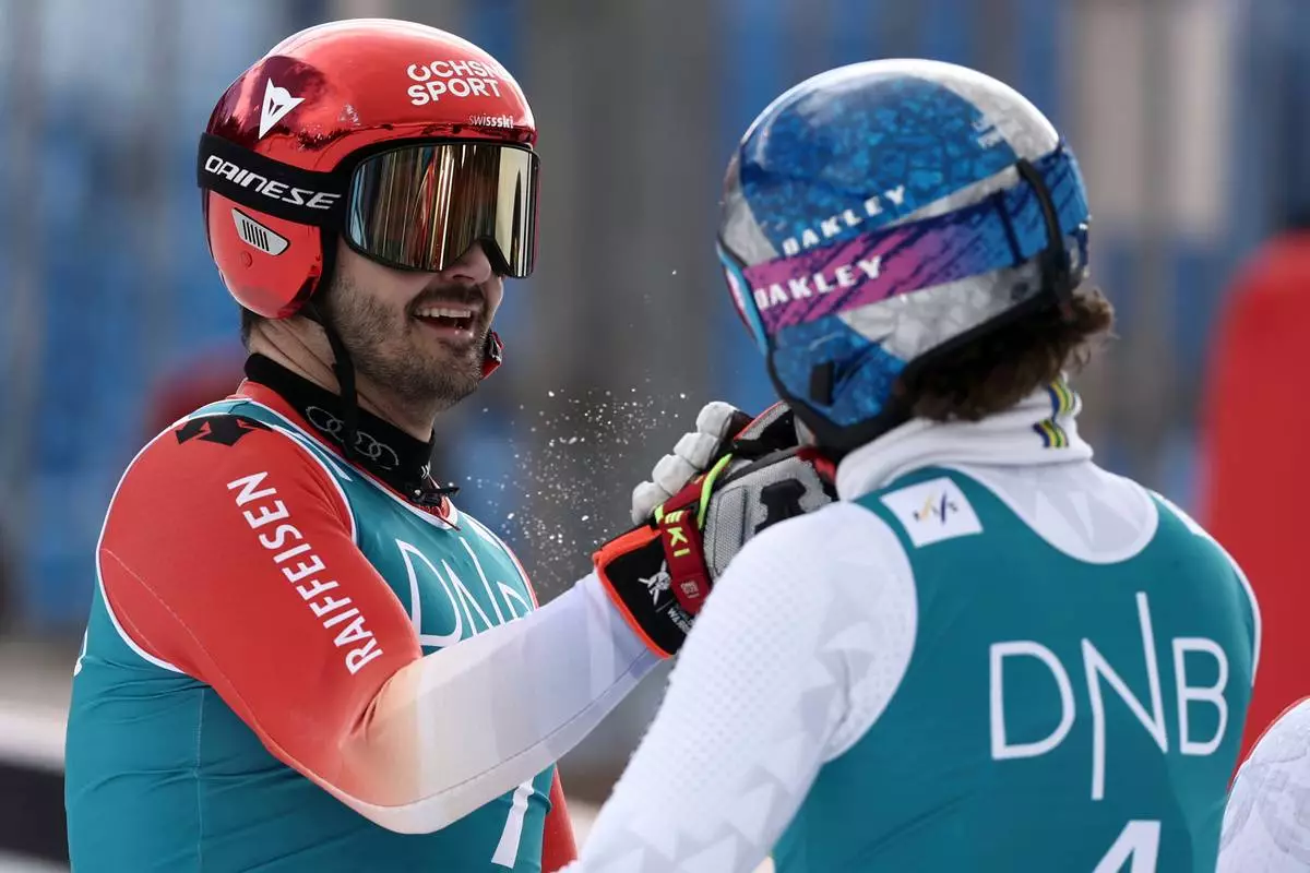 Brazil's Lucas Pinheiro Braathen is congratulated by Switzerland's Loic Meillard, left, after winning an alpine ski, men's giant slalom discipline title, at the Lillehammer World Cup Finals, in Hafjell, Norway, Tuesday, March 24, 2026. (AP Photo/Gabriele Facciotti)