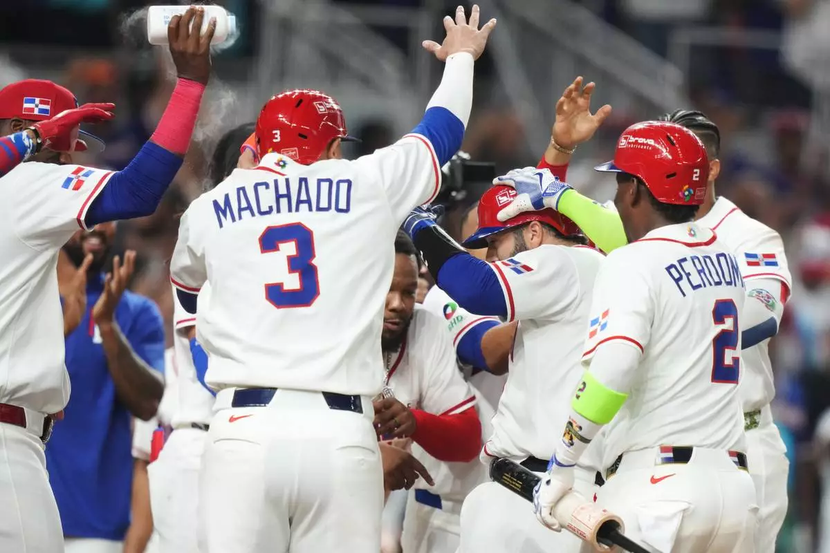 Dominican Republic's Austin Wells, second right, is congratulated by teammates after hitting a three-run home run to end the game early in the seventh inning of a World Baseball Classic quarterfinal game against South Korea, Friday, March 13, 2026, in Miami. (AP Photo/Lynne Sladky)