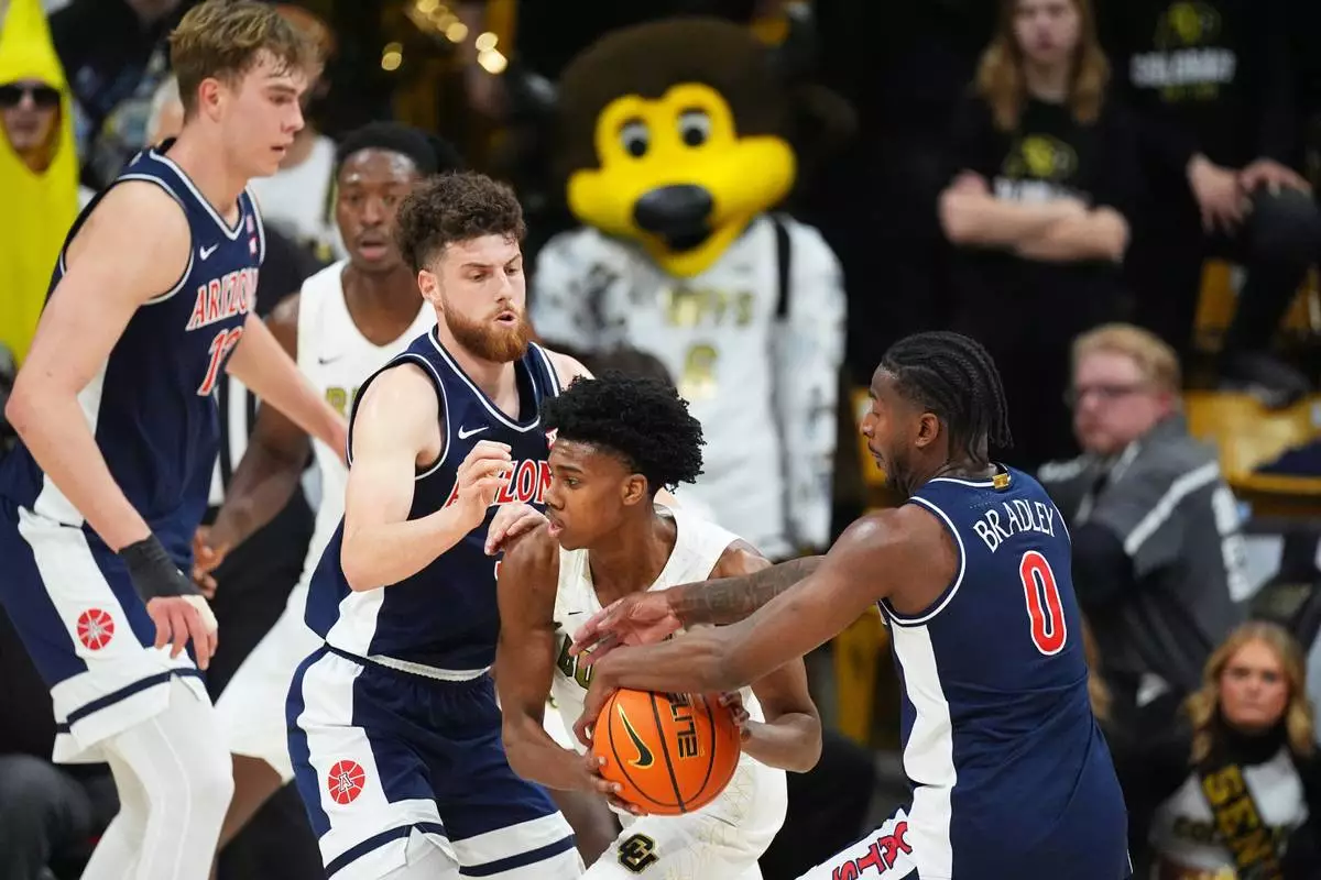 Colorado guard Isaiah Johnson, third from left, gets tied up with the ball by Arizona guard Jaden Bradley (0), guard Anthony Dell'orso, second from left, and center Motiejus Krivas, left, in the first half of an NCAA college basketball game Saturday, March 7, 2026, in Boulder, Colo. (AP Photo/David Zalubowski)