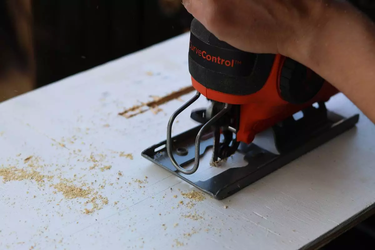 Felicia Fonseca uses a jigsaw to cut slits into a piece of plywood for a wedding sign at a do-it-yourself party at an apartment in Flagstaff, Ariz., Sunday, February 15, 2026. (AP Photo/Cheyanne Mumphrey)