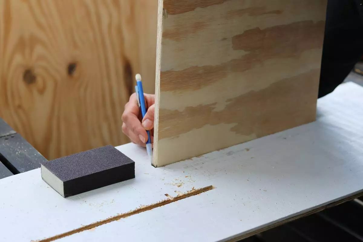 Felicia Fonseca traces the outline for a cut into a piece of plywood for a wedding sign at a do-it-yourself party at an apartment in Flagstaff, Ariz., Sunday, February 15, 2026. (AP Photo/Cheyanne Mumphrey)