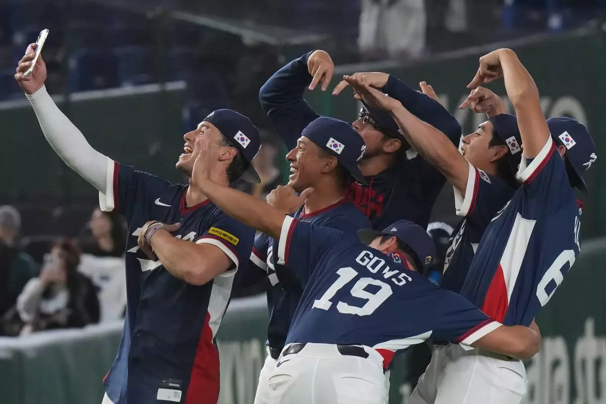 South Korea players take a selfie as they celebrate after defeating Australia in their World Baseball Classic game on Monday, March 9, 2026 in Tokyo. (AP Photo/Eugene Hoshiko)