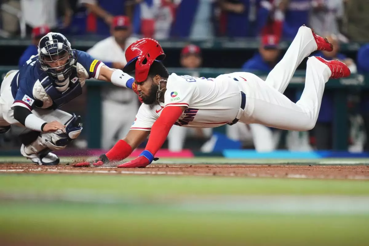 Dominican Republic's Vladimir Guerrero Jr. dives past South Korea catcher Park Dong-won to score on a double by Junior Caminero during the second inning of a World Baseball Classic quarterfinal game, Friday, March 13, 2026, in Miami. (AP Photo/Lynne Sladky)