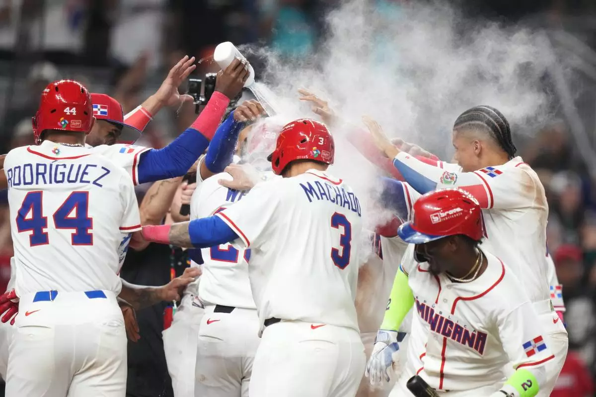 Dominican Republic's Austin Wells (28) gets doused as he celebrates with teammates after hitting a three-run home run to end the game early in the seventh inning of a World Baseball Classic quarterfinal game against South Korea, Friday, March 13, 2026, in Miami. (AP Photo/Lynne Sladky)
