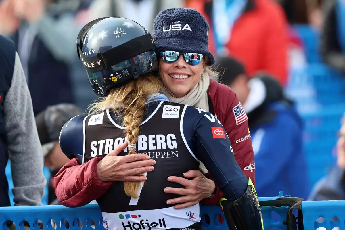 United States' Mikaela Shiffrin, back to camera, is hugged by her mother Eileen at the finish area of an alpine ski, women's giant slalom race, at the Lillehammer World Cup Finals, in Hafjell, Norway, Wednesday, March 25, 2026. (AP Photo/Marco Trovati)