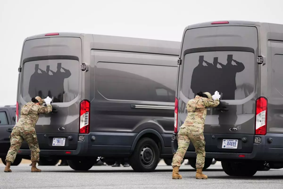 Door attendants U.S. Air Force Master Sgt. Christina Jiminez and Senior Airman Awng Dingrin secure the doors of the transfer vans containing the remains of U.S. Army Reserve soldiers Maj. Jeffrey O'Brien, 45, of Indianola, Iowa, Capt. Cody Khork, 35, of Winter Haven, Florida, Chief Warrant Officer 3 Robert Marzan, 54, of Sacramento, Sgt. 1st Class Nicole Amor, 39, of White Bear Lake, Minnesot, Sgt. 1st Class Noah Tietjens, 42, of Bellevue, Nebraska and Sgt. Declan Coady, 20, of West Des Moines, Iowa, who were killed in a drone strike at a command center in Kuwait after the U.S. and Israel launched its military campaign against Iran, during a casualty return, Saturday, March 7, 2026, at Dover Air Force Base, Del. (AP Photo/Mark Schiefelbein)