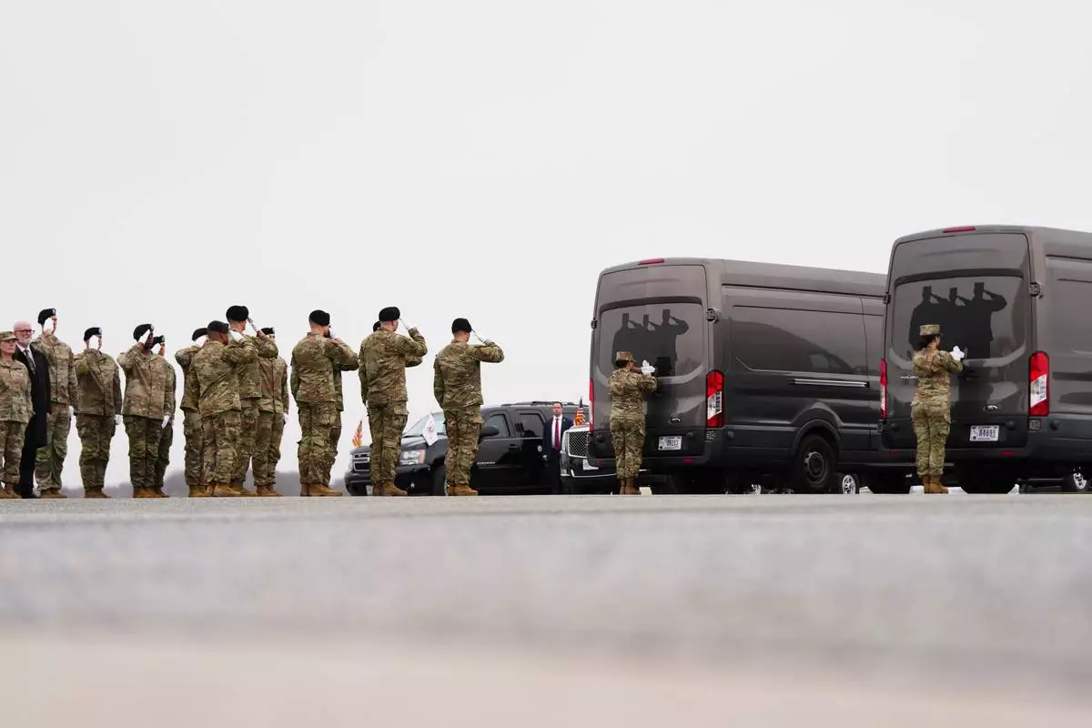 An Army carry team salute transfer vans with the remains of U.S. Army Reserve soldiers Maj. Jeffrey O'Brien, 45, of Indianola, Iowa, Capt. Cody Khork, 35, of Winter Haven, Florida, Chief Warrant Officer 3 Robert Marzan, 54, of Sacramento, Sgt. 1st Class Nicole Amor, 39, of White Bear Lake, Minnesot, Sgt. 1st Class Noah Tietjens, 42, of Bellevue, Nebraska and Sgt. Declan Coady, 20, of West Des Moines, Iowa, who were killed in a drone strike at a command center in Kuwait after the U.S. and Israel launched its military campaign against Iran, during a casualty return, Saturday, March 7, 2026, at Dover Air Force Base, Del. (AP Photo/Julia Demaree Nikhinson)