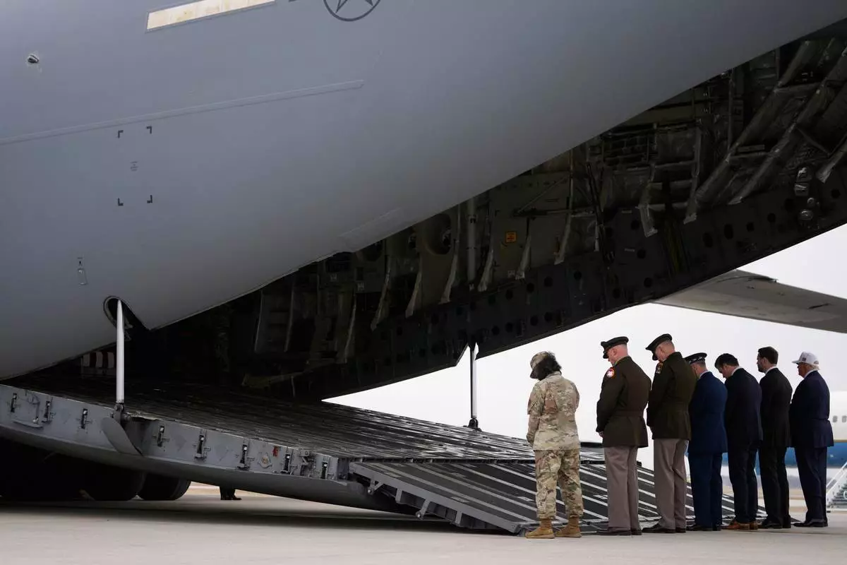 From right, President Donald Trump, Vice President JD Vance, Defense Secretary Pete Hegseth and Chairman of the Joint Chiefs of Staff Gen. Dan Caine say a prayer before a casualty return for the soldiers who were killed in a drone strike at a command center in Kuwait after the U.S. and Israel launched its military campaign against Iran, Saturday, March 7, 2026, at Dover Air Force Base, Del. (AP Photo/Mark Schiefelbein)