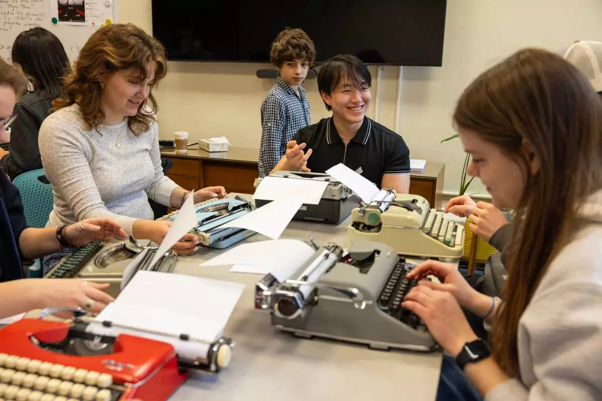 Ratchaphon Lertdamrongwong, a sophomore at Cornell University, laughs with classmates while using a typewriter for a German writing assignment on Friday, March 20, 2026, in Ithaca, N.Y. The professor, Grit Matthias Phelps, brings out the typewriters once a semester for her students to use. (AP Photo/Lauren Petracca)