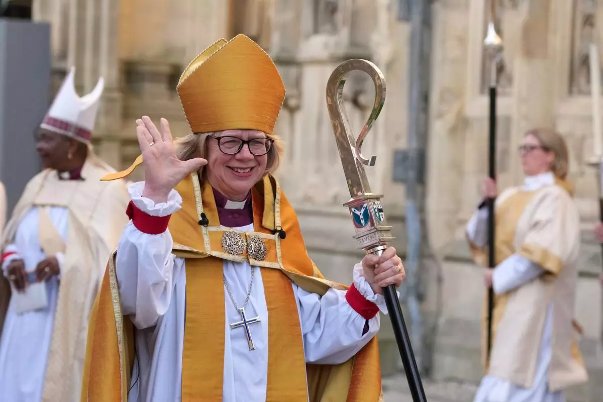 Sarah Mullally waves as she leaves after the Enthronement Ceremony installing her as archbishop of Canterbury in Canterbury, England, Wednesday, March 25, 2026, the first woman ever to lead the Church of England. (AP Photo/Alastair Grant)
