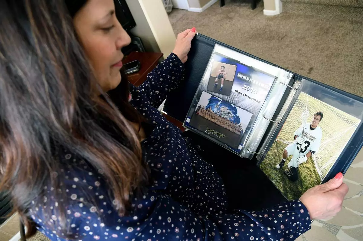 Kim Osterman shows photos of her son Max, who she says died after taking fentanyl he bought from a dealer on Snapchat, in her living room in Thornton, Colo., on Thursday, March 26, 2026. (AP Photo/Thomas Peipert)
