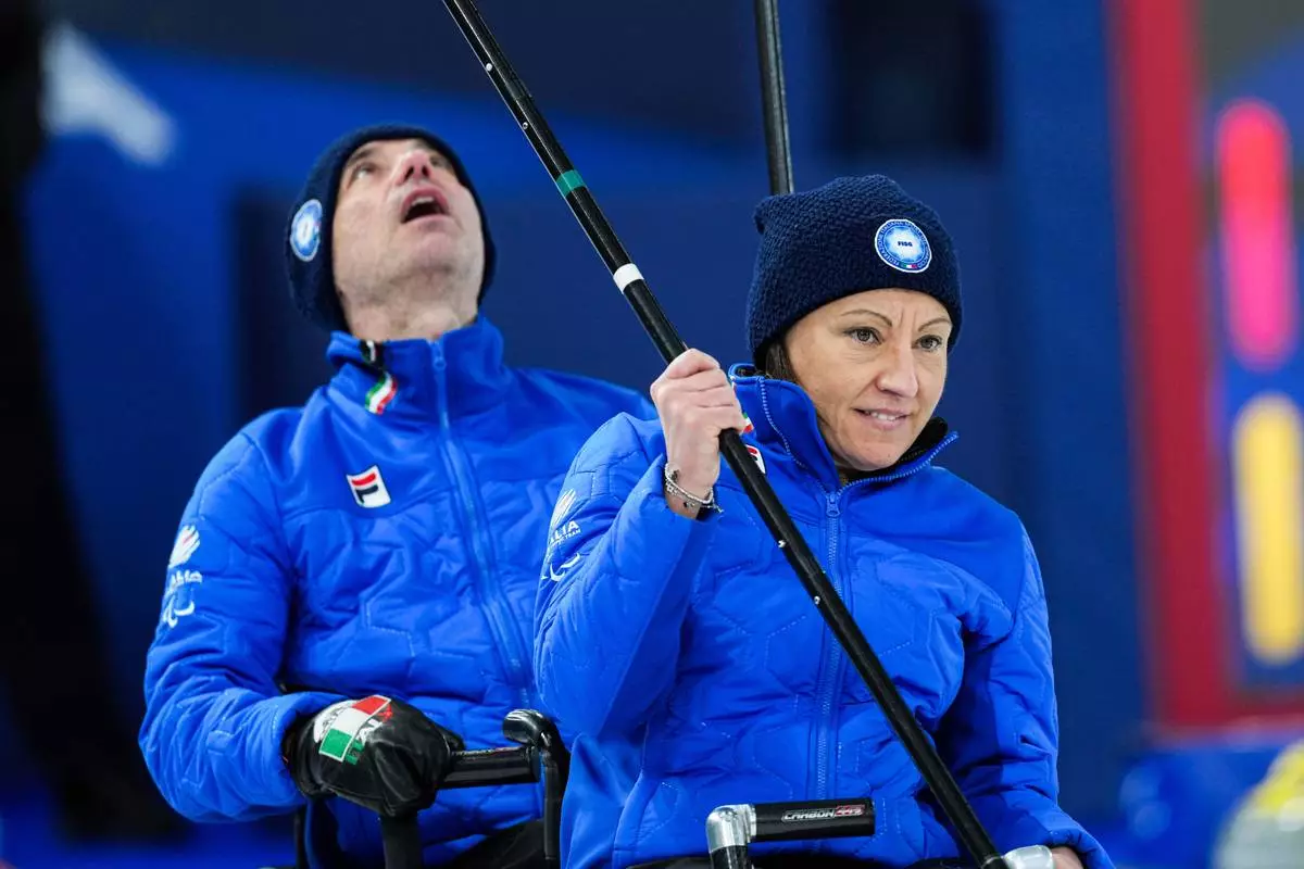 Italy's Orietta Berto, left, and Paolo Ioriatti compete against China during a wheelchair curling mixed doubles match at the 2026 Winter Paralympics in Cortina d'Ampezzo, Italy, Thursday, March 5, 2026. (AP Photo/Evgeniy Maloletka)