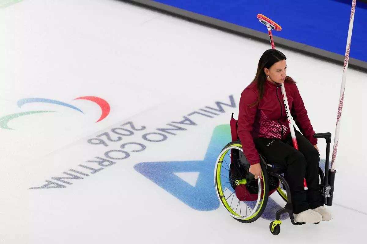 Polina Rozkova of Latvia, rides to the position during a wheelchair curling mixed doubles round robin session against Great Britain at the 2026 Winter Paralympics, in Cortina d'Ampezzo, Italy, Thursday, March 5, 2026. (AP Photo/Evgeniy Maloletka)