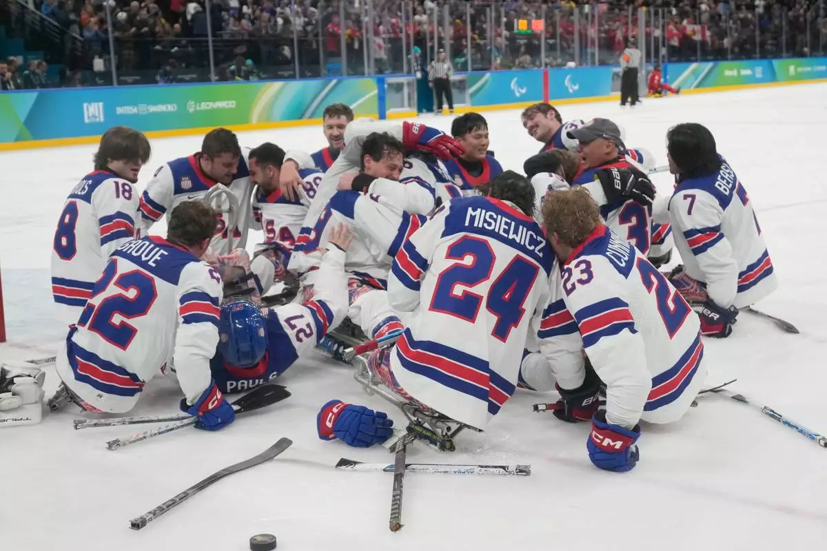US players celebrate after winning the gold medal at the end of the ice hockey match between United States and Canada at the 2026 Winter Paralympics, in Milan, Italy, Sunday, March 15, 2026. (AP Photo/Luca Bruno)