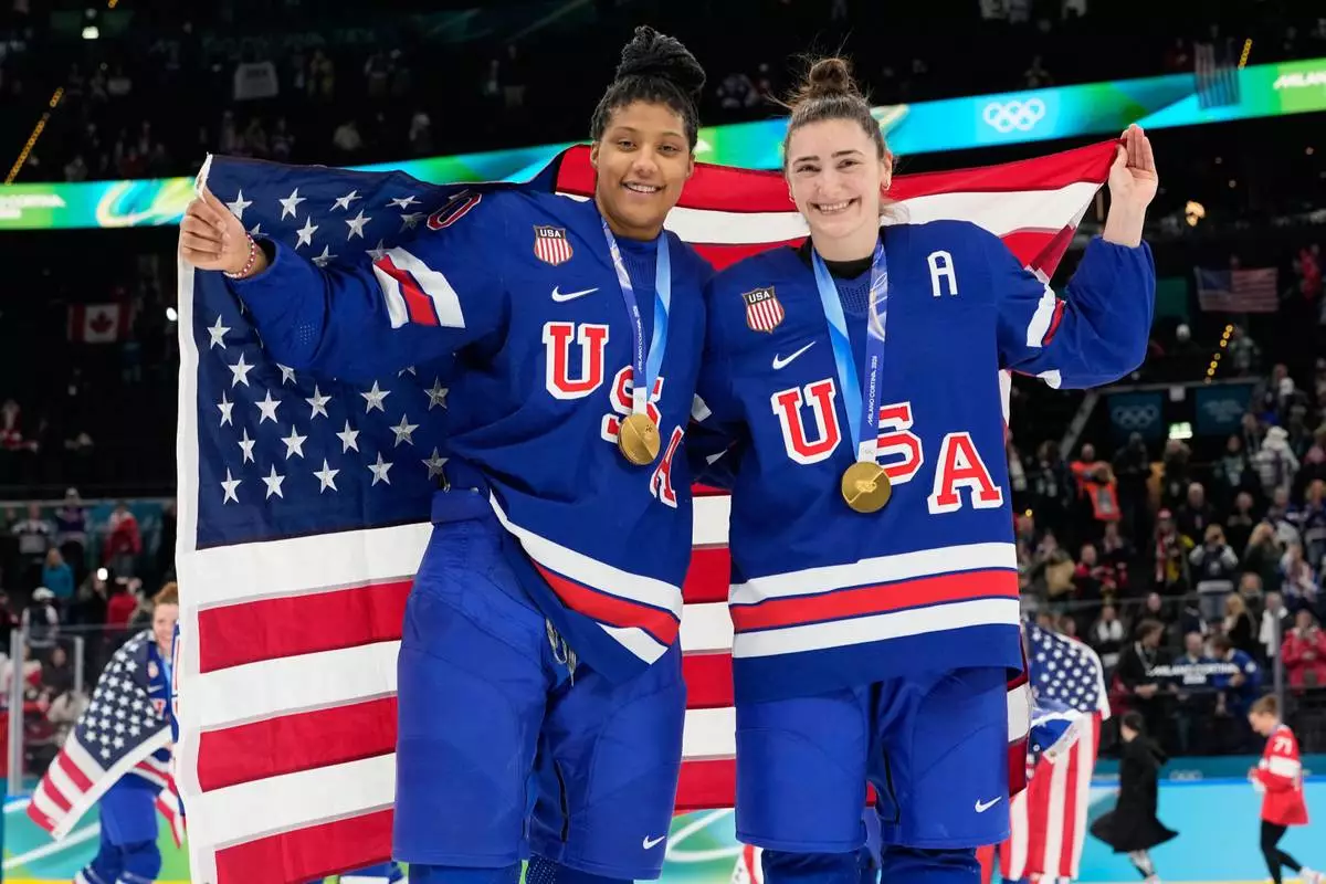 United States' Laila Edwards, left, and United States' Megan Keller celebrate after victory ceremony for women's ice hockey at the 2026 Winter Olympics, in Milan, Italy, Thursday, Feb. 19, 2026. (AP Photo/Hassan Ammar)
