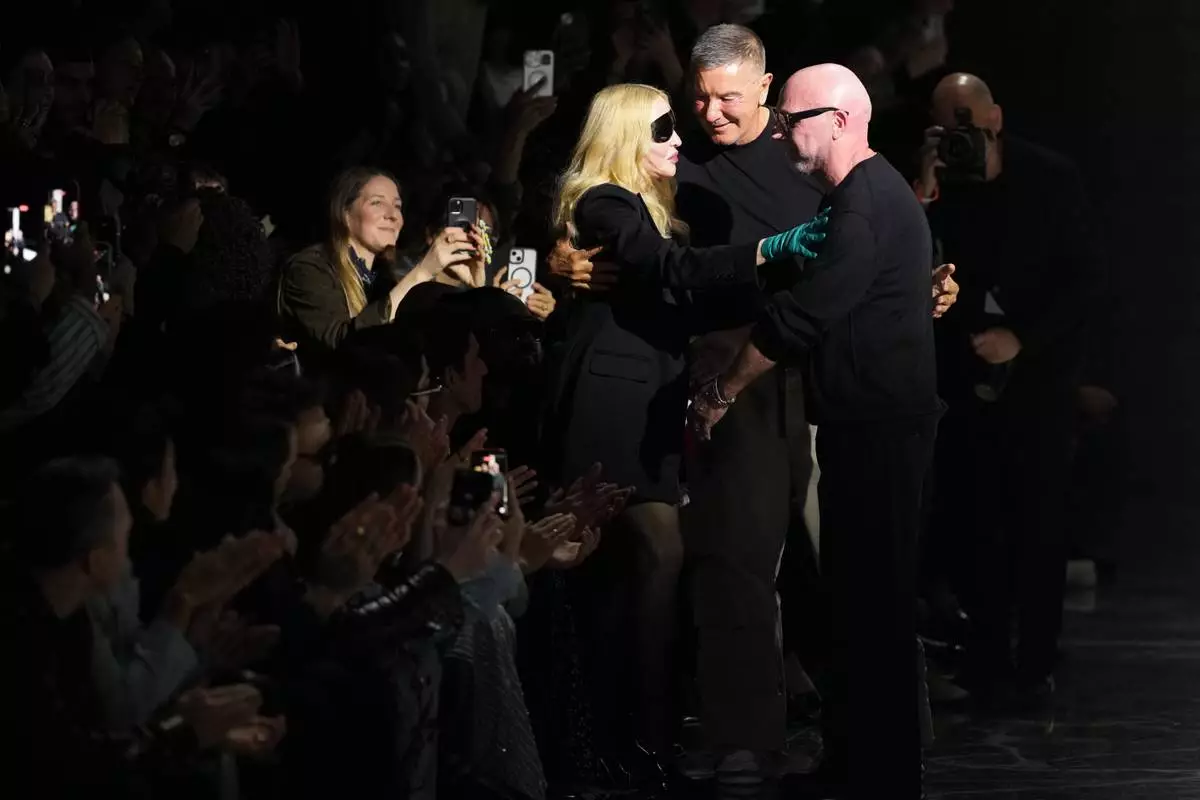 Madonna congratulates Domenico Dolce, right, and Stefano Gabbana at the end of the Dolce &amp; Gabbana Fall/Winter 2026-2027 Women's collection, presented in Milan, Italy, Saturday, Feb. 28, 2026. (AP Photo/Antonio Calanni)
