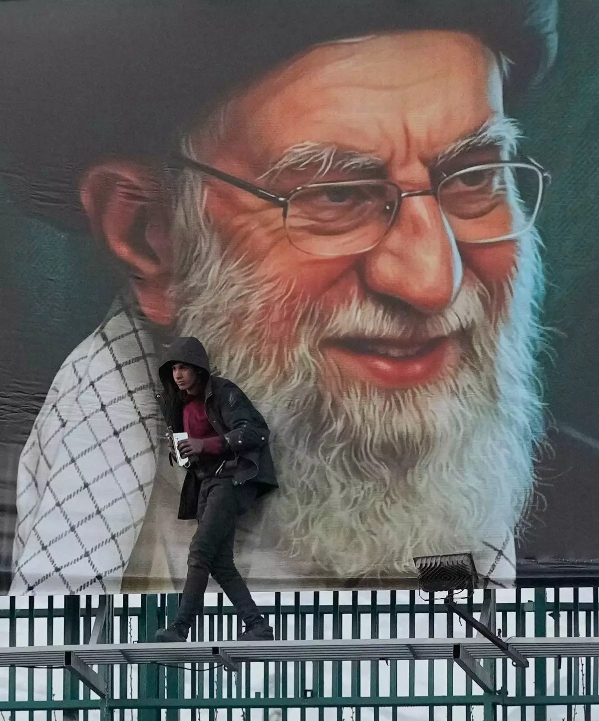 A worker helps install a billboard bearing a portrait of the late Iranian Supreme Leader Ayatollah Ali Khamenei, who was killed during the ongoing joint U.S.-Israeli military campaign, in Tehran, Iran, Monday, March 2, 2026. (AP Photo/Vahid Salemi)