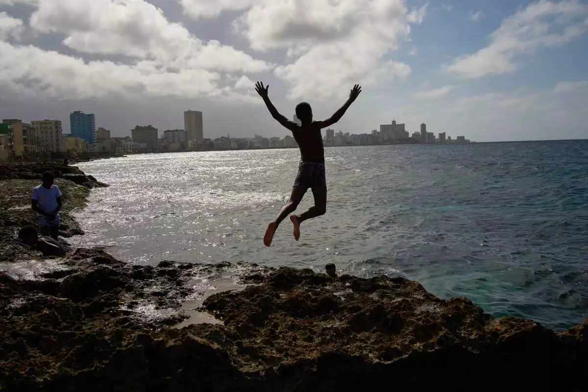A youth jumps into the sea during a blackout in Havana, Wednesday, March 4, 2026. (AP Photo/Ramon Espinosa)