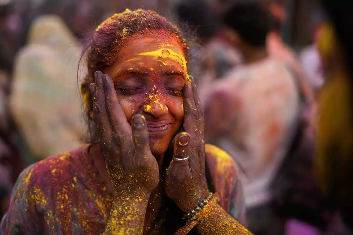 A woman is smeared with colored powder during celebrations for the Holi festival in Hyderabad, India, Wednesday, March 4, 2026. (AP Photo/Mahesh Kumar A.)