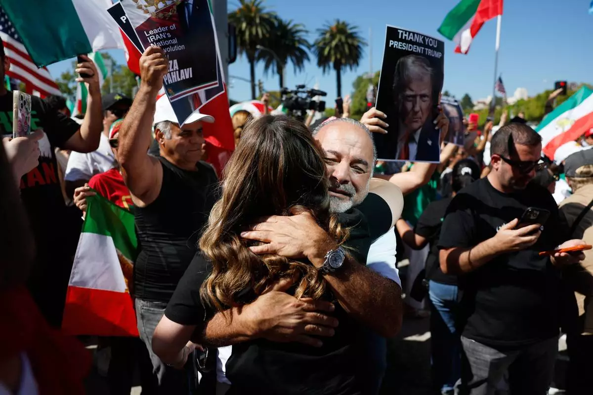 Demonstrators embrace as they march in reaction to the U.S. and Israeli strikes on Iran on Saturday, Feb. 28, 2026, in Los Angeles. (AP Photo/Caroline Brehman)