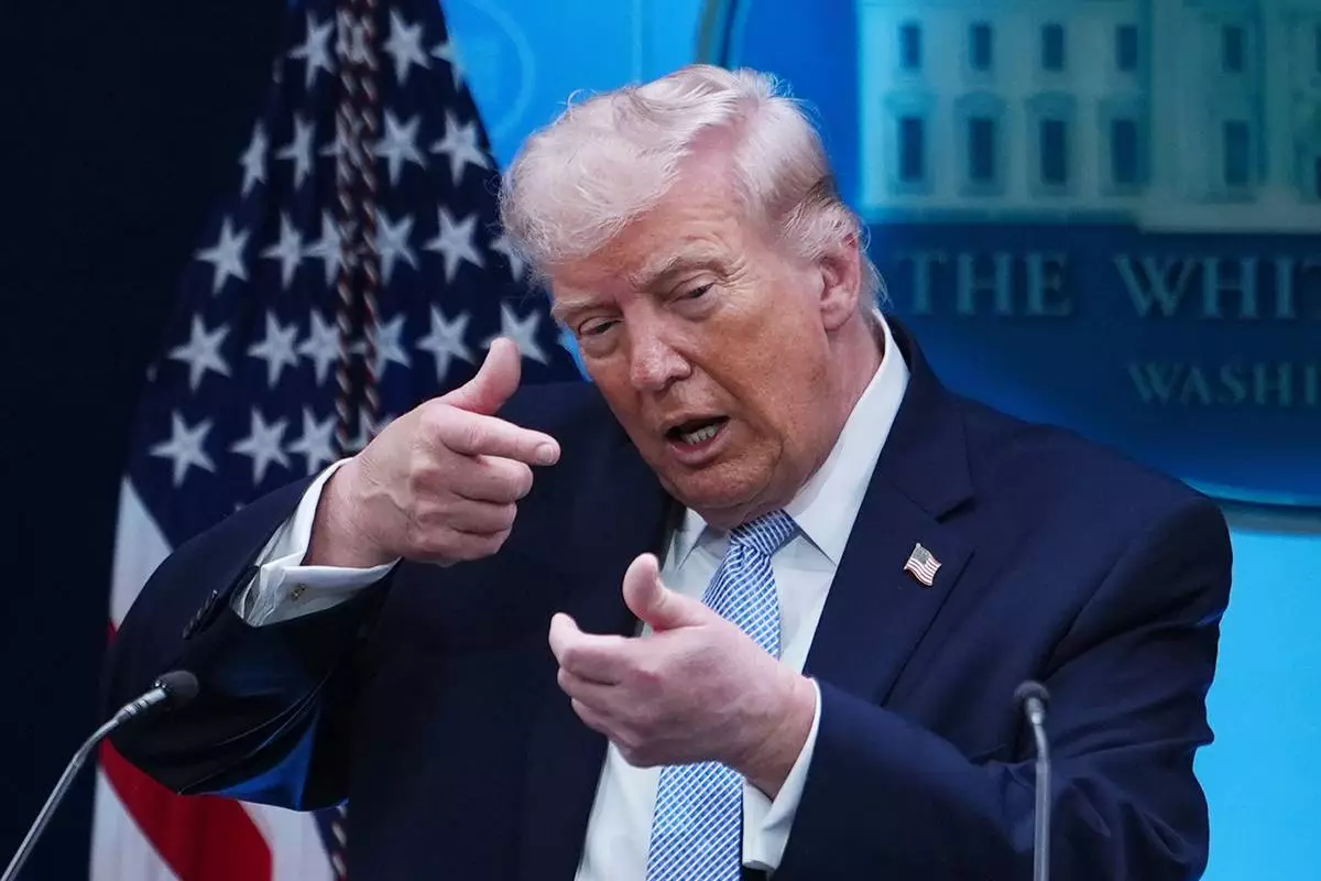 FILE - President Donald Trump pretends to aim a sniper gun while speaking with reporters in the James Brady Press Briefing Room at the White House, Monday, April 6, 2026, in Washington. (AP Photo/Julia Demaree Nikhinson, File)
