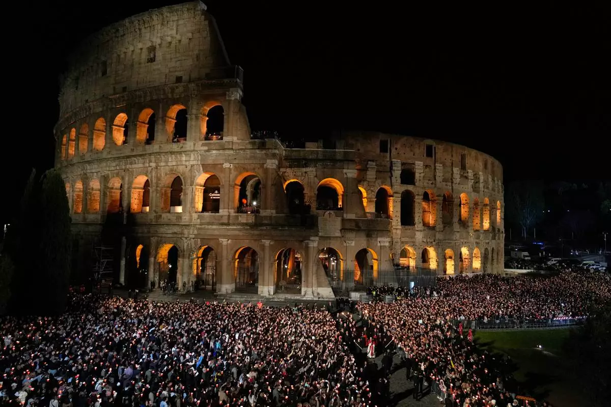 FILE - Pope Leo XIV carries a lightweight, 1.5-meter (5-foot) wooden cross during the Via Crucis, the torchlit Good Friday Stations of the Cross procession at the Colosseum in Rome, Friday, April 3, 2026, which symbolically retraces Jesus Christ's steps to his crucifixion on Calvary in Jerusalem. (AP Photo/Gregorio Borgia, File)
