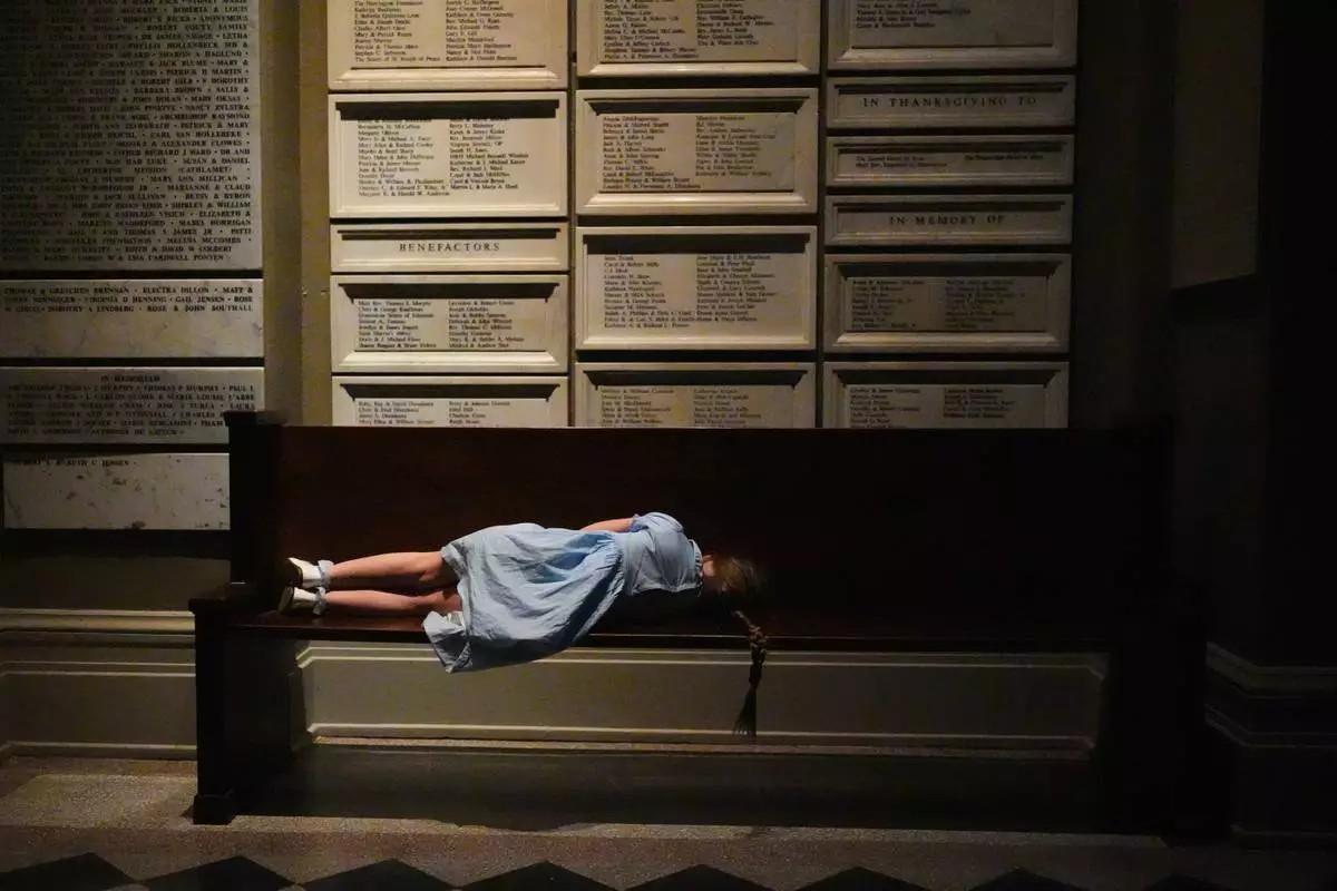 FILE - A young worshipper rests on a bench outside the nave of the cathedral during an Easter vigil at St. James Cathedral, Saturday, April 4, 2026, in Seattle. (AP Photo/Lindsey Wasson, File)