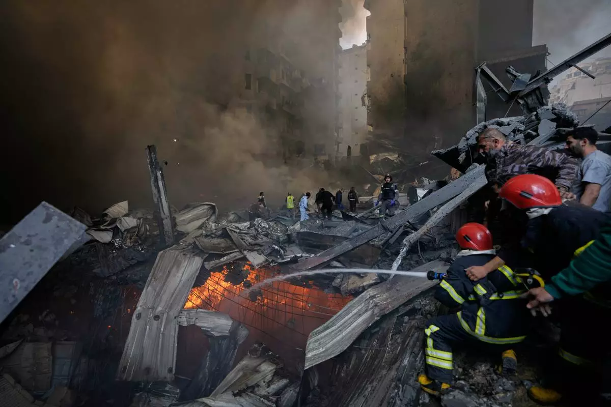 FILE - Firefighters try to put out flames at the site of an Israeli airstrike that struck an apartment building in Beirut, Lebanon, Wednesday, April 8, 2026. (AP Photo/Bilal Hussein, File)