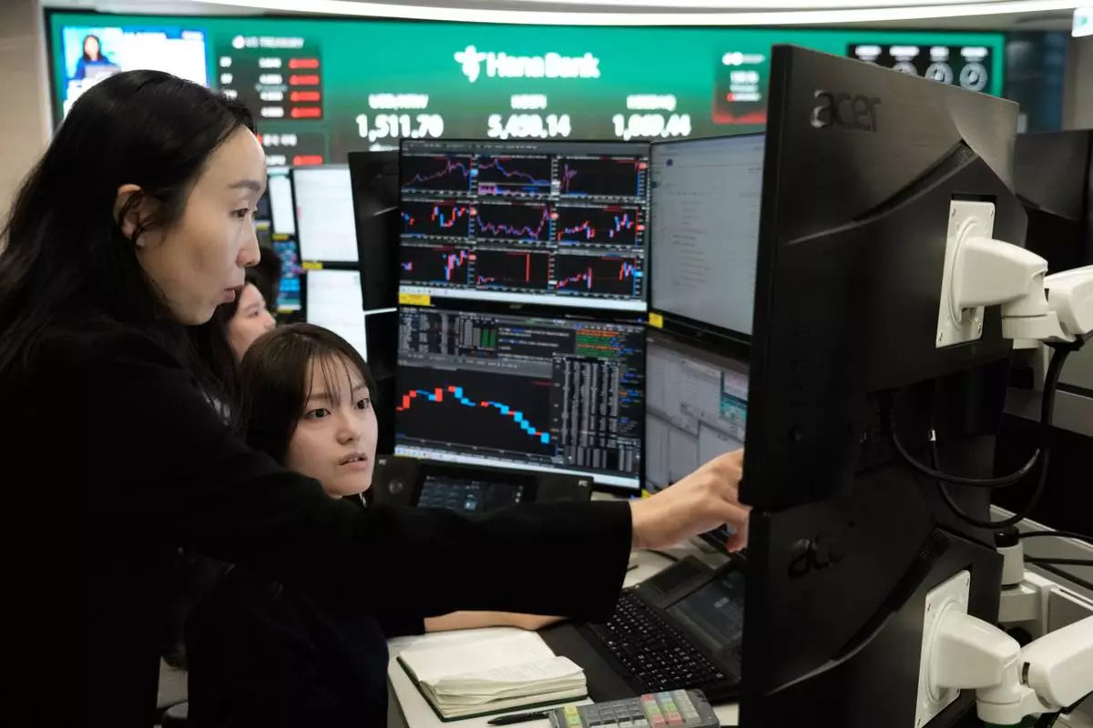Currency traders watch monitors at the foreign exchange dealing room of the Hana Bank headquarters in Seoul, South Korea, Monday, April 6, 2026. (AP Photo/Ahn Young-joon)