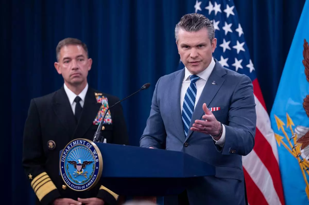 Defense Secretary Pete Hegseth is joined by Adm. Brad Cooper, left, as he speaks to members of the media during a press briefing at the Pentagon, Thursday, April 16, 2026 in Washington. (AP Photo/Kevin Wolf)