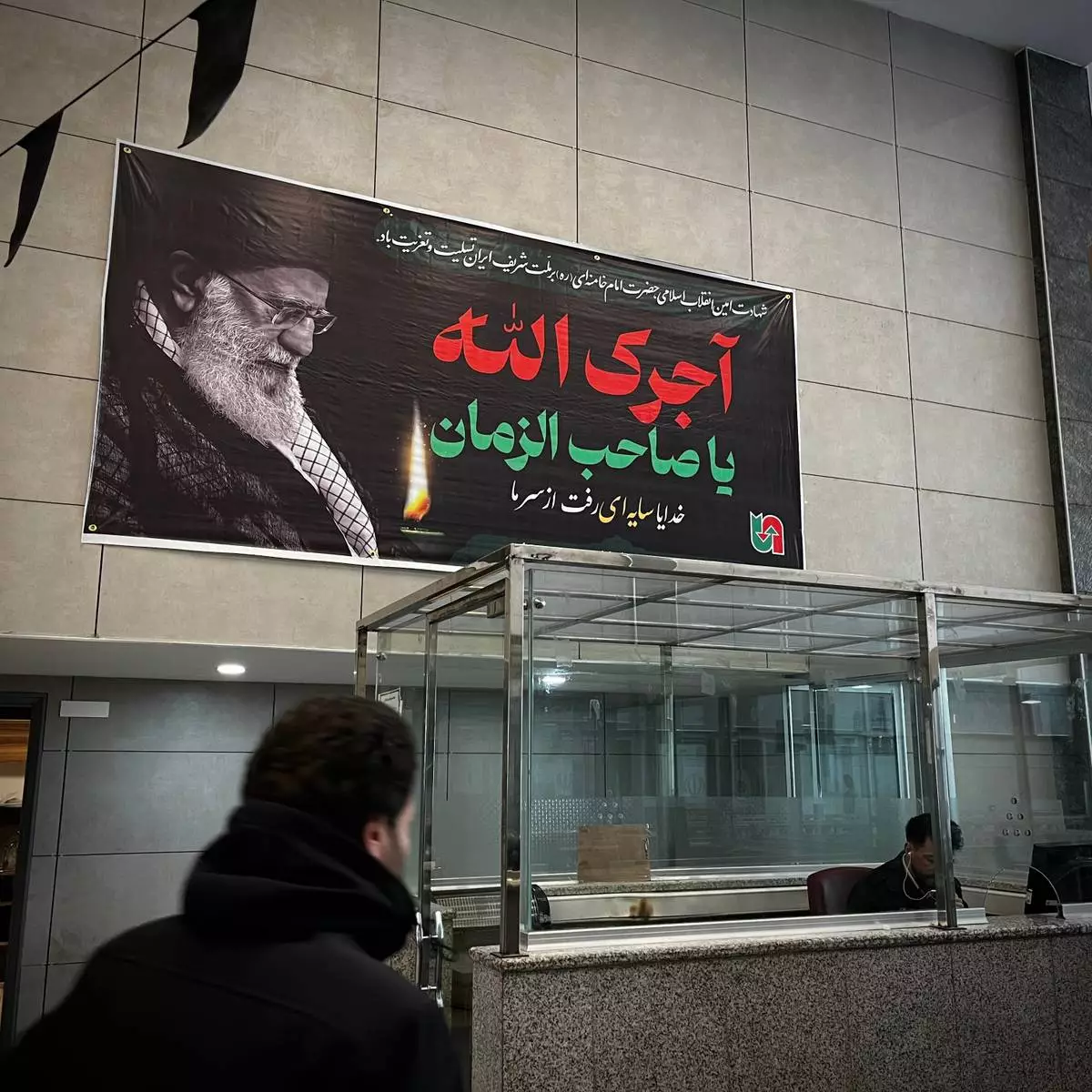 Under a poster of Iran's slain Supreme Leader Ayatollah Ali Khamenei, Iranian border police check passports at a border crossing between Turkey and Iran in Razi, Iran, Saturday, April 4, 2026.. (AP Photo/Francisco Seco)