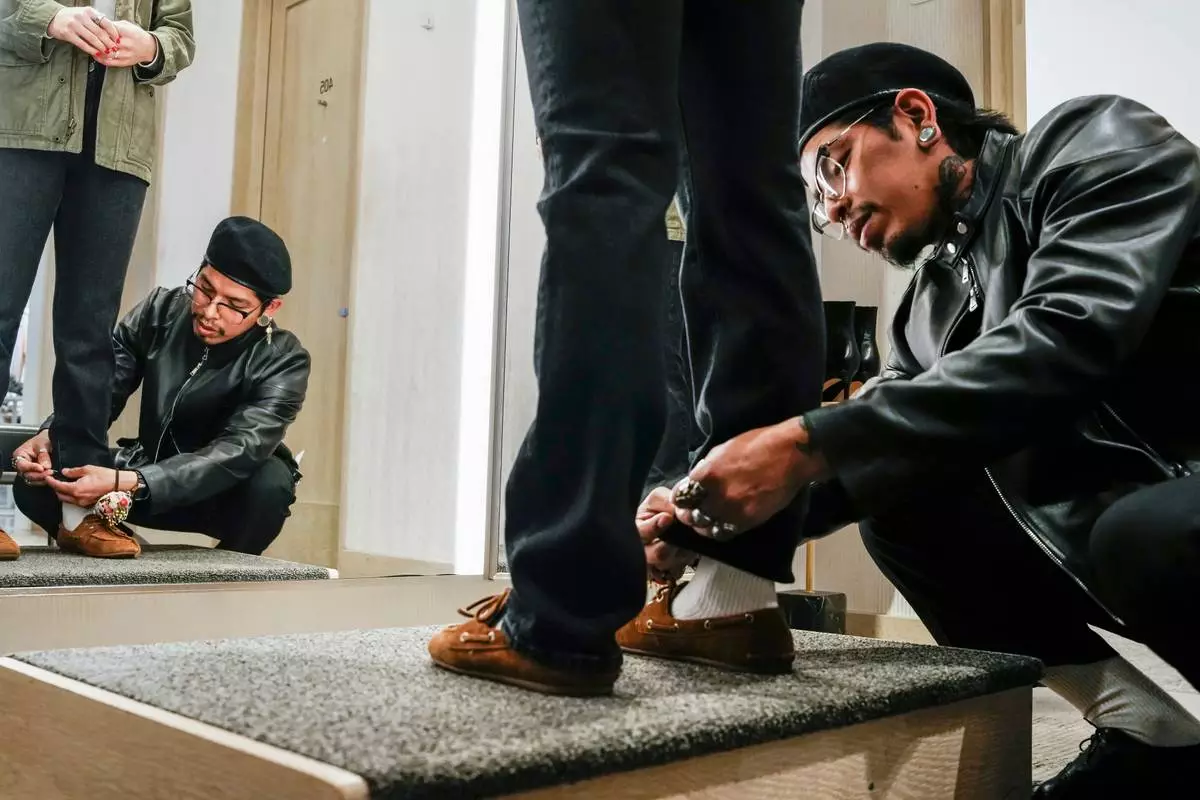Tailor Marco Lema, 35, of Ecuador, measures a denim alteration at Nordstrom headquarters in New York, Monday, March 23, 2026. (AP Photo/Eduardo Munoz Alvarez)