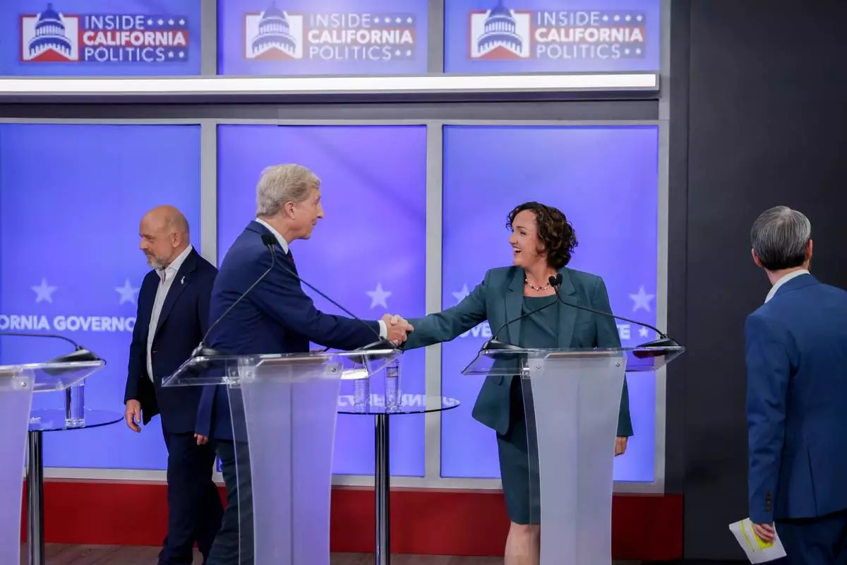 Tom Steyer, center left, and Katie Porter, candidates in California's gubernatorial race, shake hands during a debate Wednesday, April 22, 2026, in San Francisco. (Jason Henry/Pool Photo via AP)