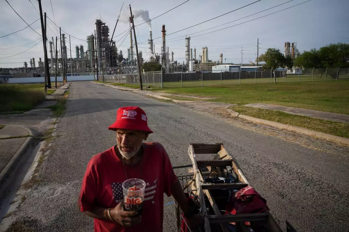 Gavino Rivera talks about the decline of the Hillcrest neighborhood Thursday, Nov. 16, 2023, as he gathers scrap metal near a Citgo oil refinery in Corpus Christi, Texas. (Jon Shapley/Houston Chronicle via AP)