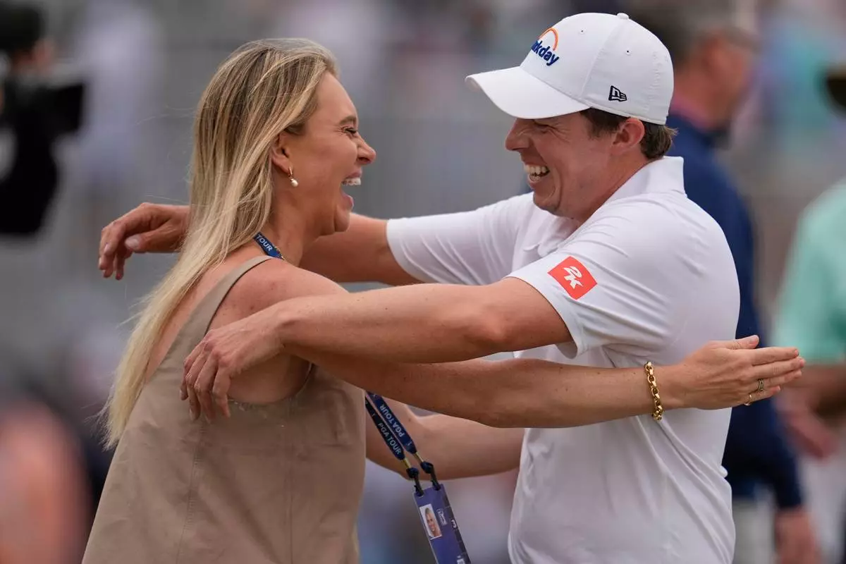 Matt Fitzpatrick, of England, right, hugs his wife Katherine Gaal after winning the RBC Heritage golf tournament Sunday, April 19, 2026, in Hilton Head, S.C. (AP Photo/Mike Stewart)
