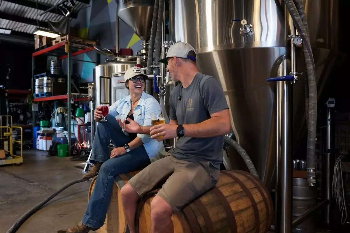 Rancher Alli Fender (left) of Flying F Ranch and Head Brewer Moe Katomski of Viewpoint Brewing Company raise a glass to their unique environmental partnership that keeps spent grains out of landfills and turns them into beef. Photo courtesy of SDFoodies.