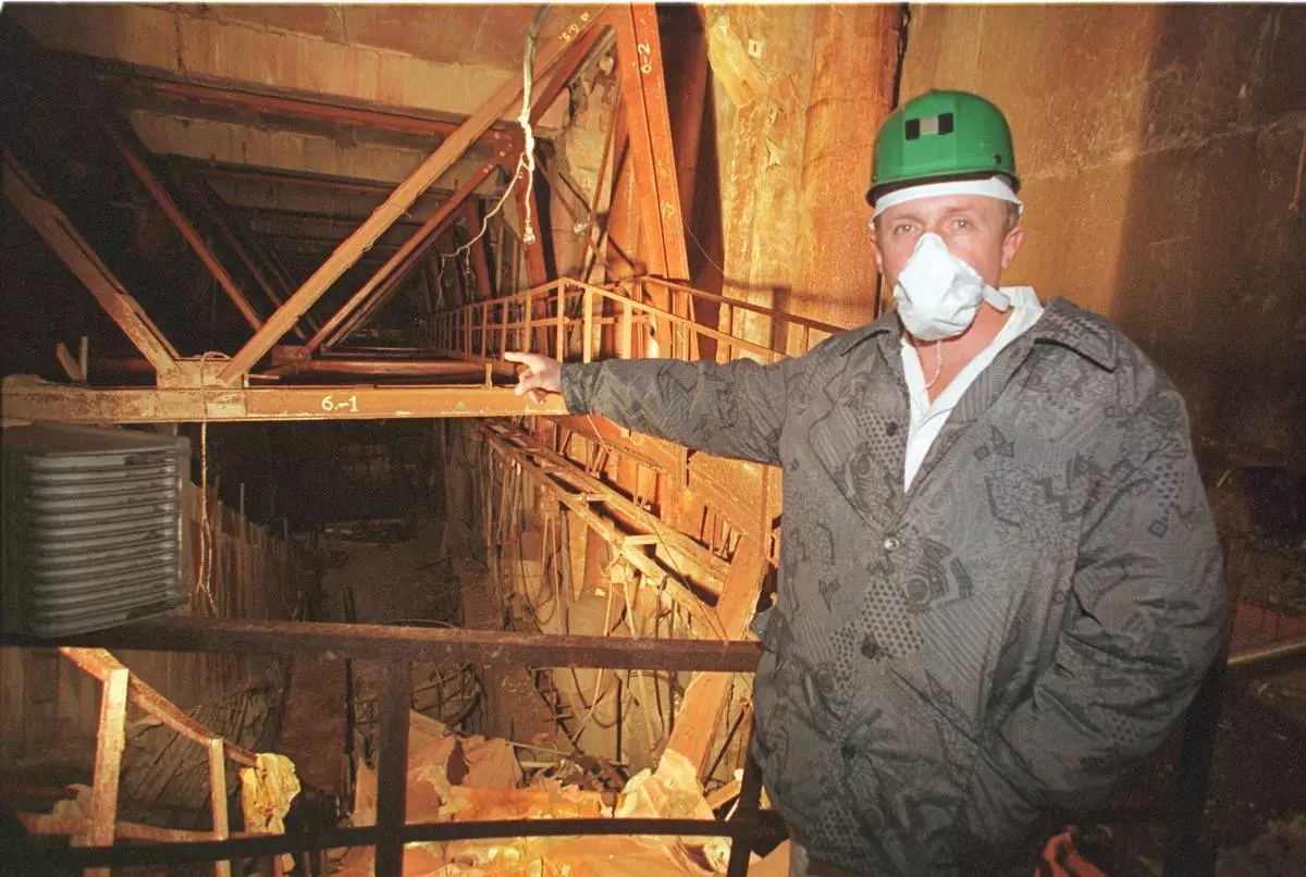 FILE - An investigator points toward damaged Reactor No. 4 inside the Chernobyl nuclear power plant in Chernobyl, Ukraine, Nov. 10, 2000. (AP Photo/Efrem Lukatsky, File)