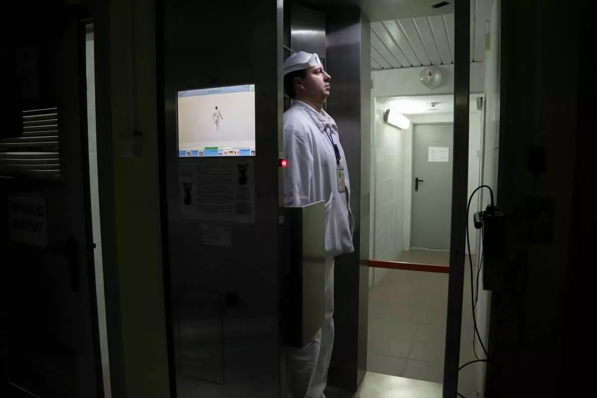 FILE - A worker checks radiation levels after leaving a nuclear waste storage site at the Chernobyl nuclear power plant in Chernobyl, Ukraine, March 23, 2016. (AP Photo/Efrem Lukatsky, File)
