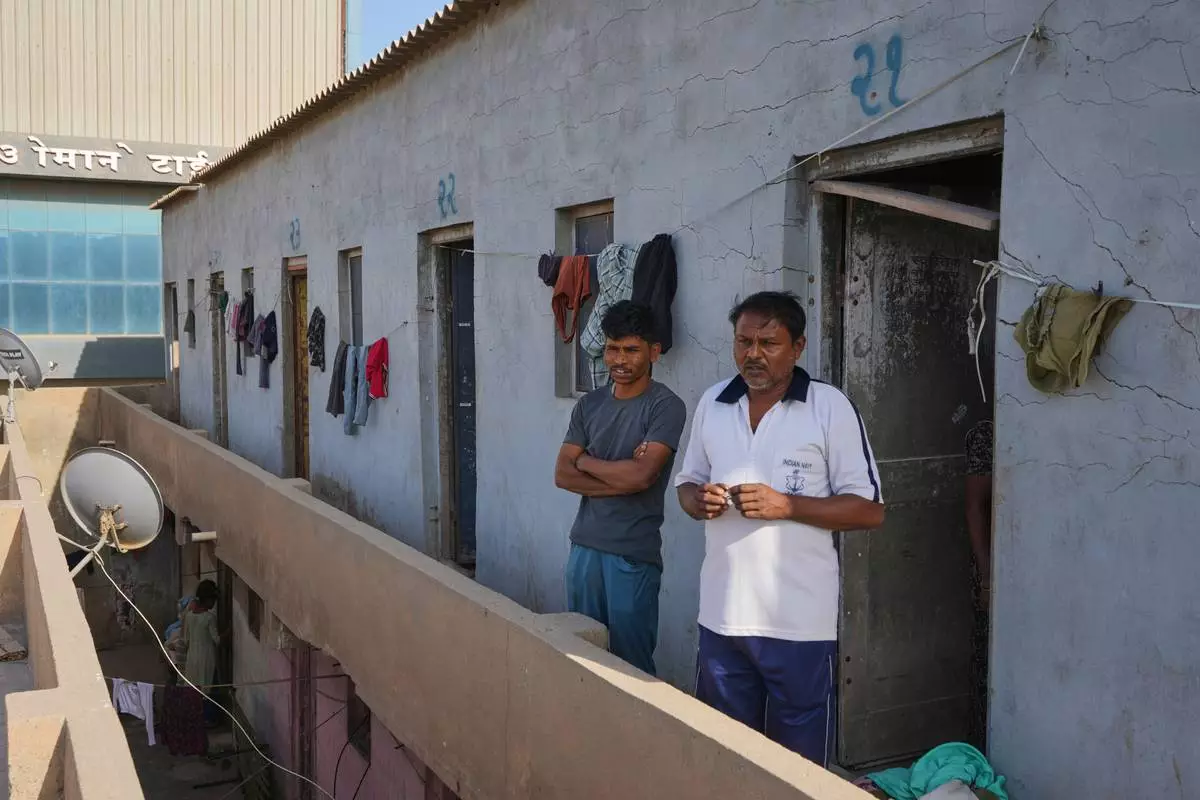 Migrant workers stand outside their deserted quarters at a ceramics factory in Morbi, in the Indian state of Gujarat, Wednesday, April 8, 2026. (AP Photo/Ajit Solanki)