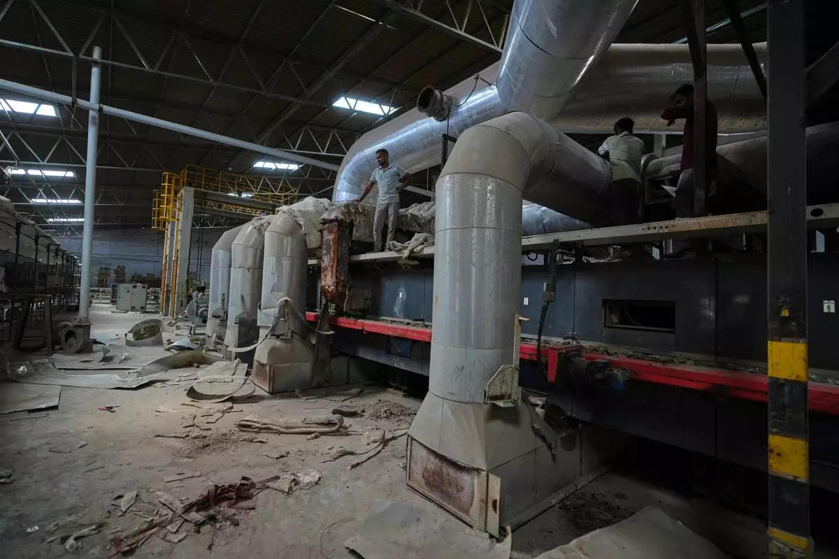 Workers arrive for maintenance work at a closed ceramics factory in Morbi, in the Indian state of Gujarat, Wednesday, April 8, 2026. (AP Photo/Ajit Solanki)