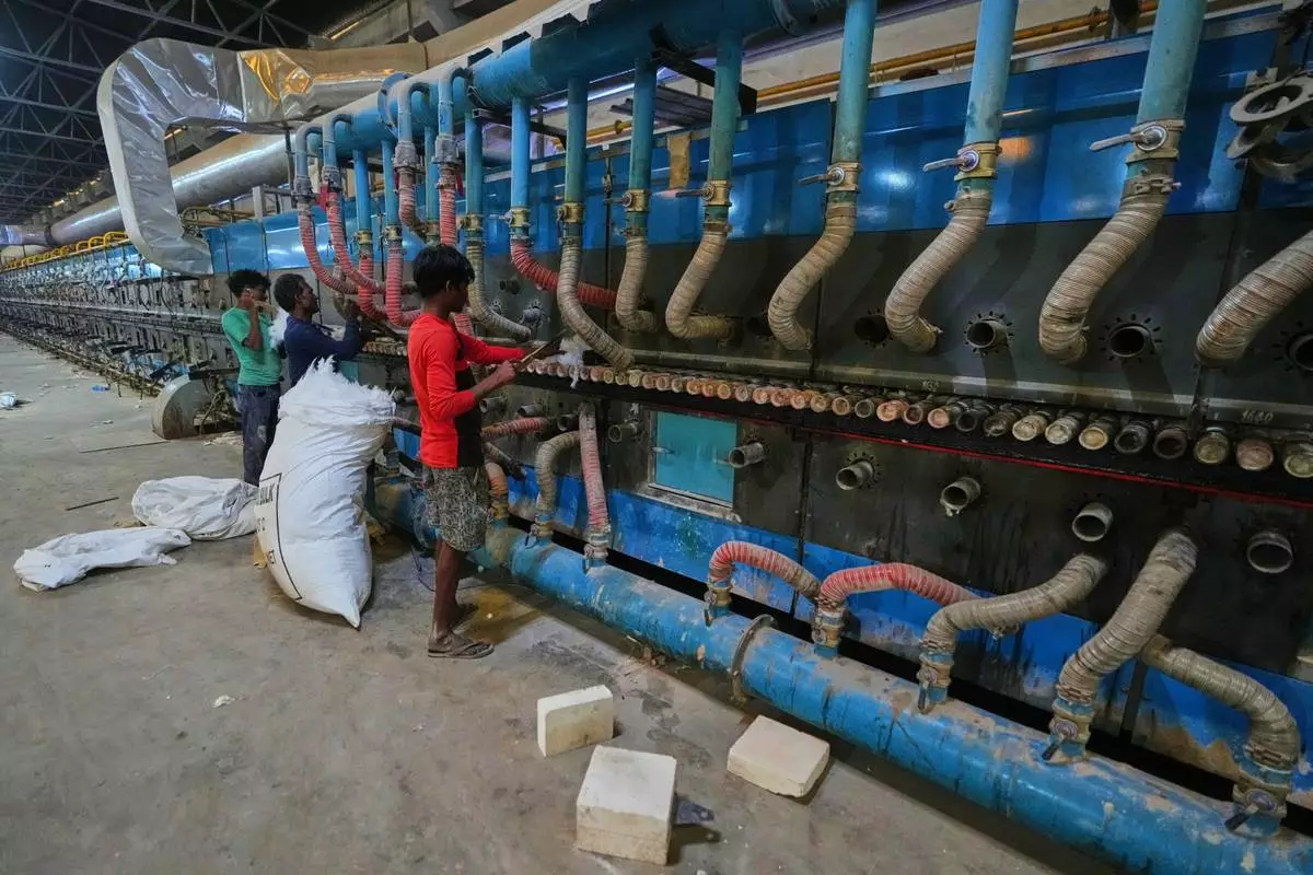 Workers perform maintenance on a machine at a shuttered ceramic factory in Morbi in the Indian state of Gujarat, Wednesday, April 8, 2026. (AP Photo/Ajit Solanki)