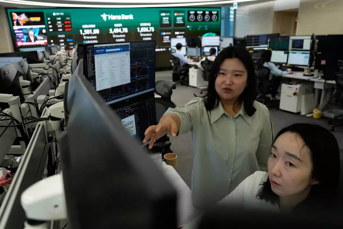 Currency traders work at the foreign exchange dealing room of the Hana Bank headquarters in Seoul, South Korea, Wednesday, April 8, 2026. (AP Photo/Ahn Young-joon)