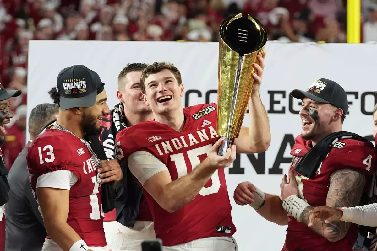 FILE - Indiana quarterback Fernando Mendoza holds the trophy after Indiana defeated Miami in a College Football Playoff national championship game in Miami Gardens, Fla., Jan. 19, 2026, (AP Photo/Lynne Sladky, File)
