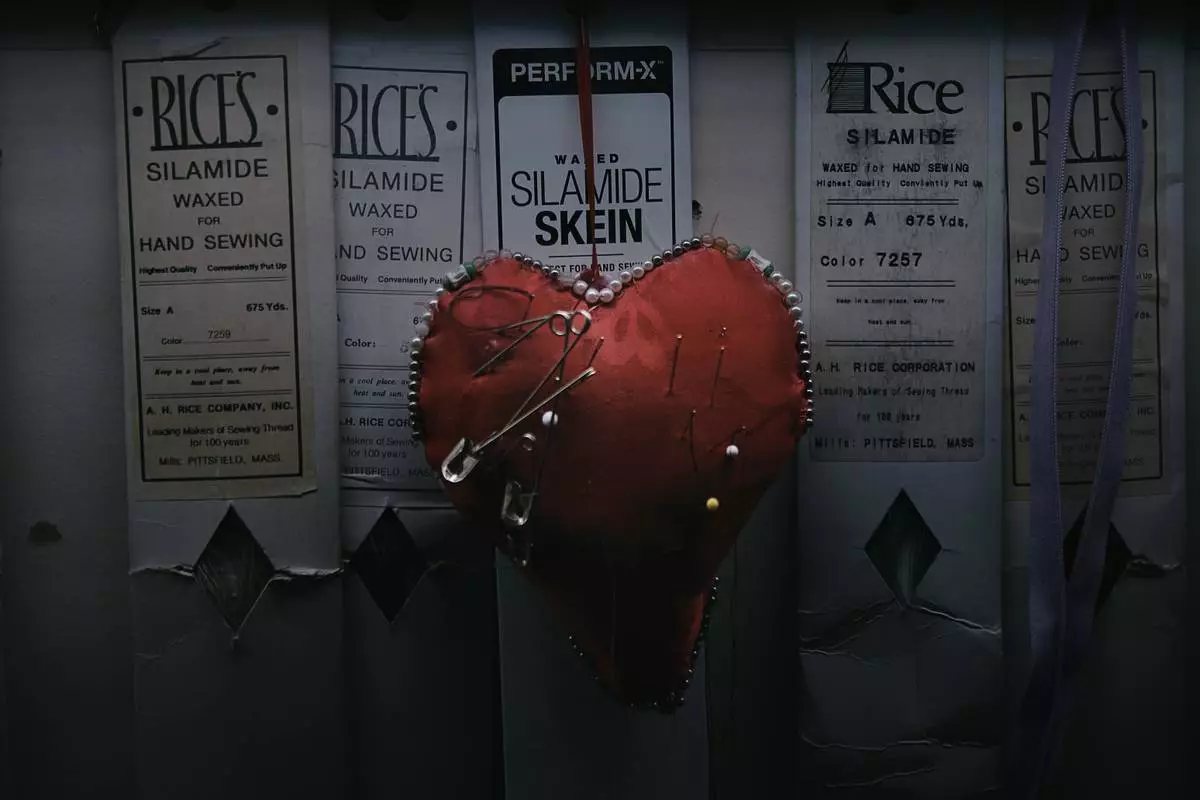 A heart-shaped pincushion bristling with needles hangs on the wall inside Kil Bae's store on Friday, March 27, 2026, in New York. (AP Photo/Andres Kudacki)