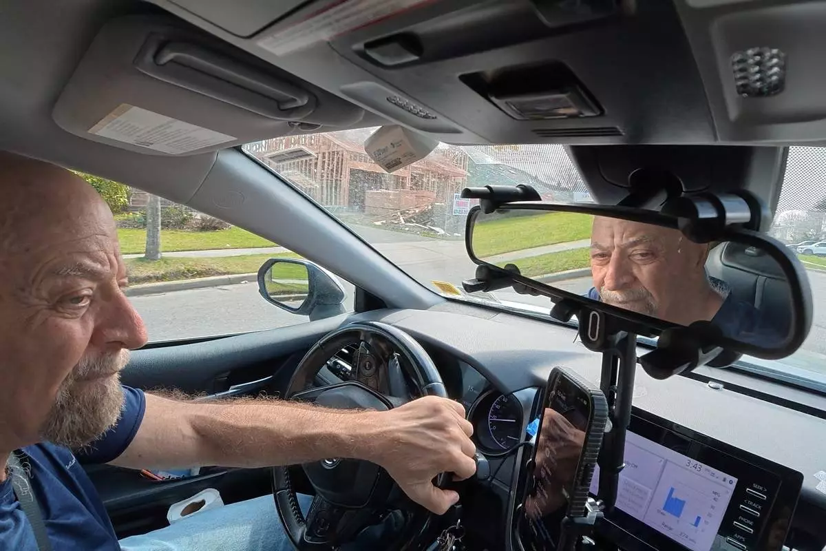 Retiree Stu Goldberg prepares to pick up passengers for Uber near Plainview, N.Y., on Tuesday, March 31, 2026. (AP Photo/Emily Wang Fujiyama)
