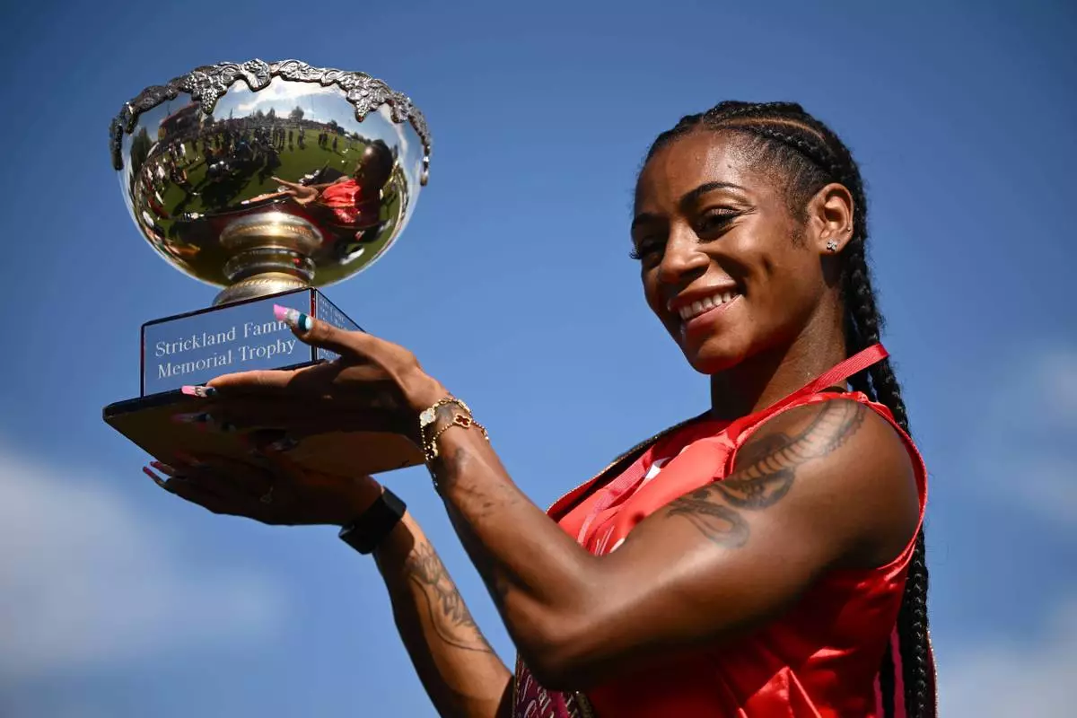 Sha'Carri Richardson of the U.S., holds her trophy as she celebrates winning the women's Stawell Gift in Stawell, Australia, Monday, April 6, 2026. (Joel Carrett/AAP Image via AP)