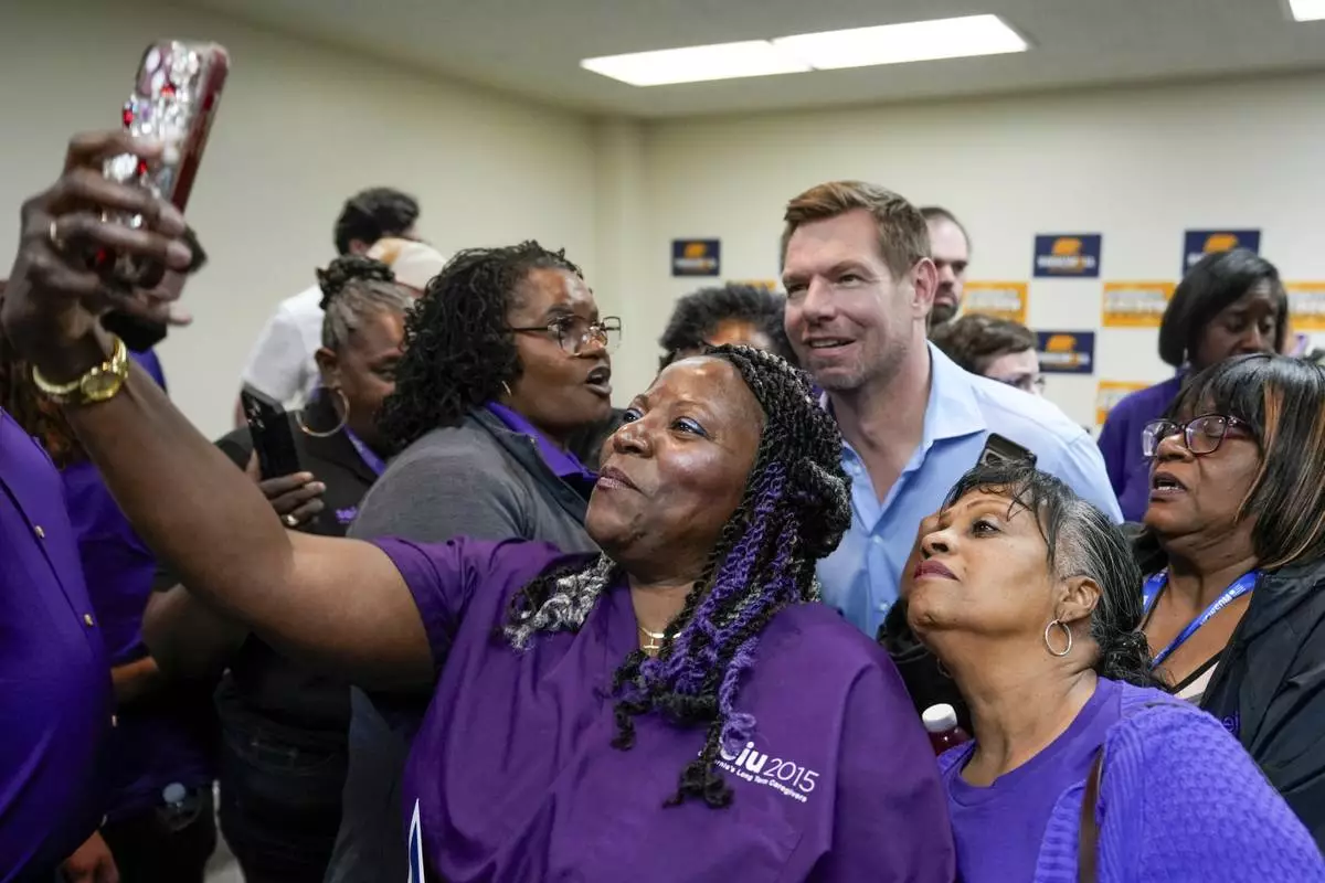 California gubernatorial candidate Rep. Eric Swalwell, D-Calif., back, poses for a photo with members of the Service Employees International Union after holding a town hall meeting in Sacramento, Calif., Tuesday, April 7, 2026. (AP Photo/Rich Pedroncelli)