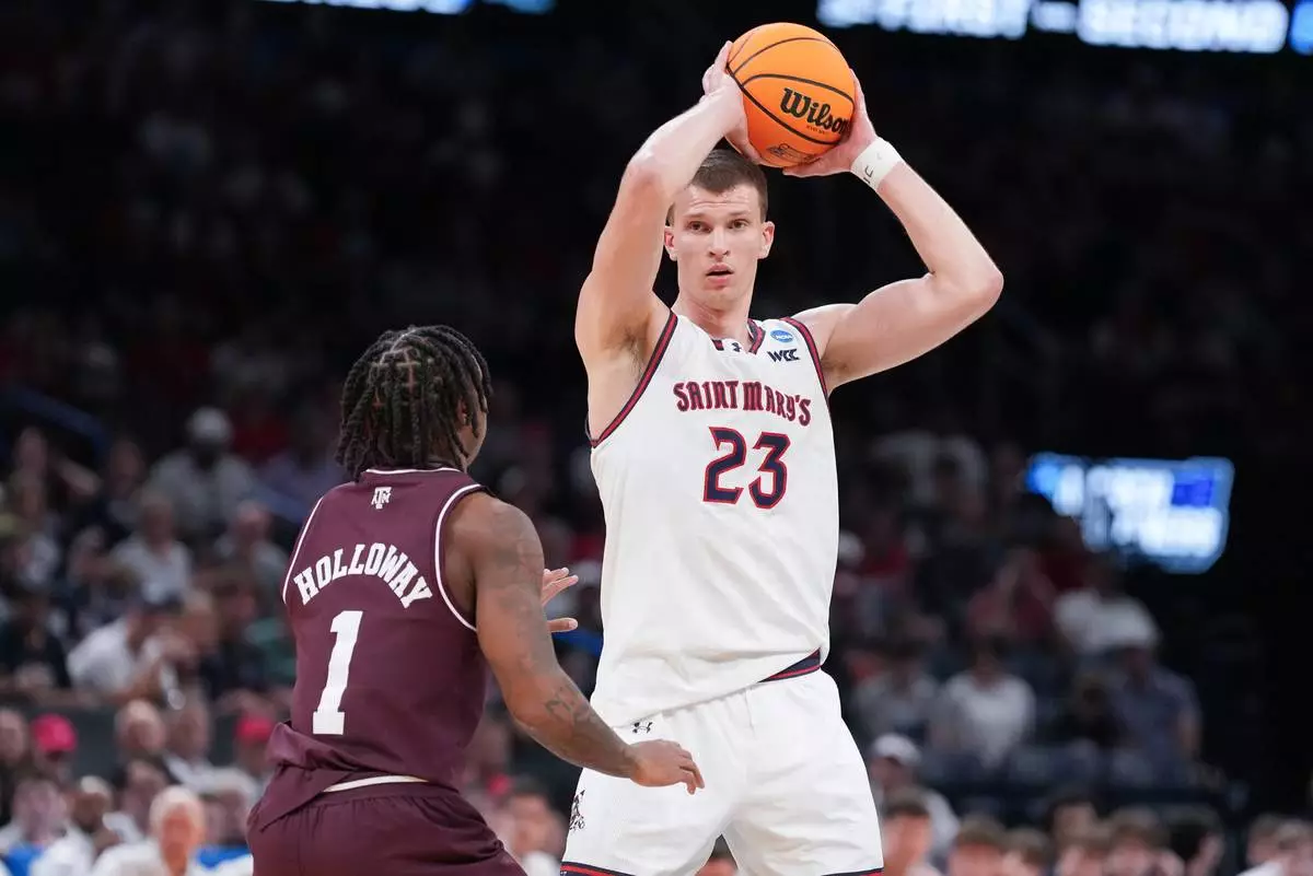 Saint Mary;s forward Paulius Murauskas (23) keeps the ball away from Texas A&amp;M guard Josh Holloway (1) during the first half in the first round of the NCAA college basketball tournament, Thursday, March 19, 2026, in Oklahoma City. (AP Photo/Kyle Phillips)